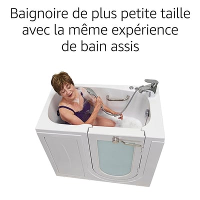 Femme âgée assise dans la baignoire à porte compacte Ella Mobile utilisant une douchette à main avec eau de bain moussante
