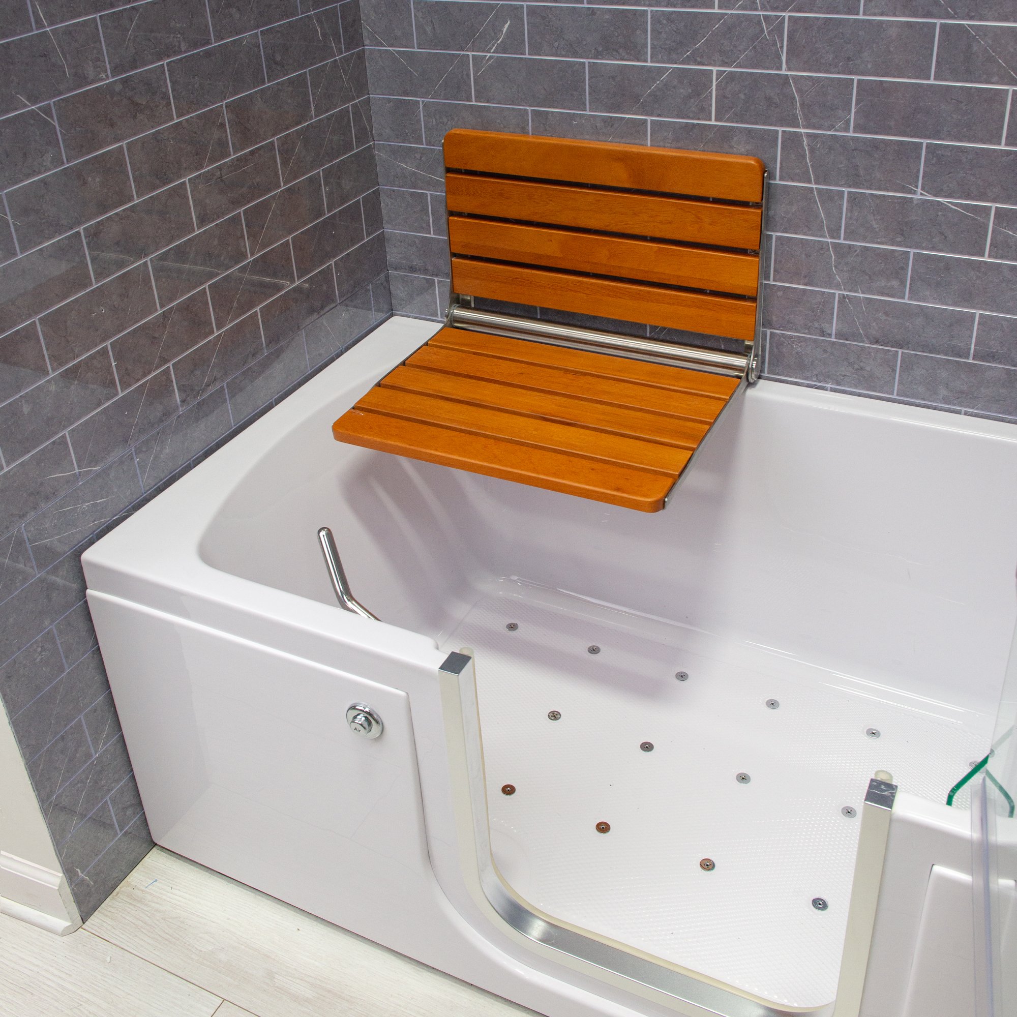 Folding teak wood shower seat mounted on the wall inside an Ella walk-in tub with air jets and low-step entry door