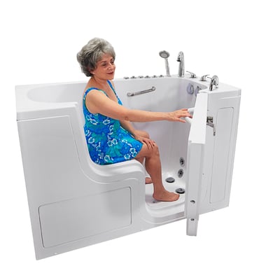 Senior woman seated in the Ella Transfer60 wheelchair accessible walk-in tub closing the outward swing door