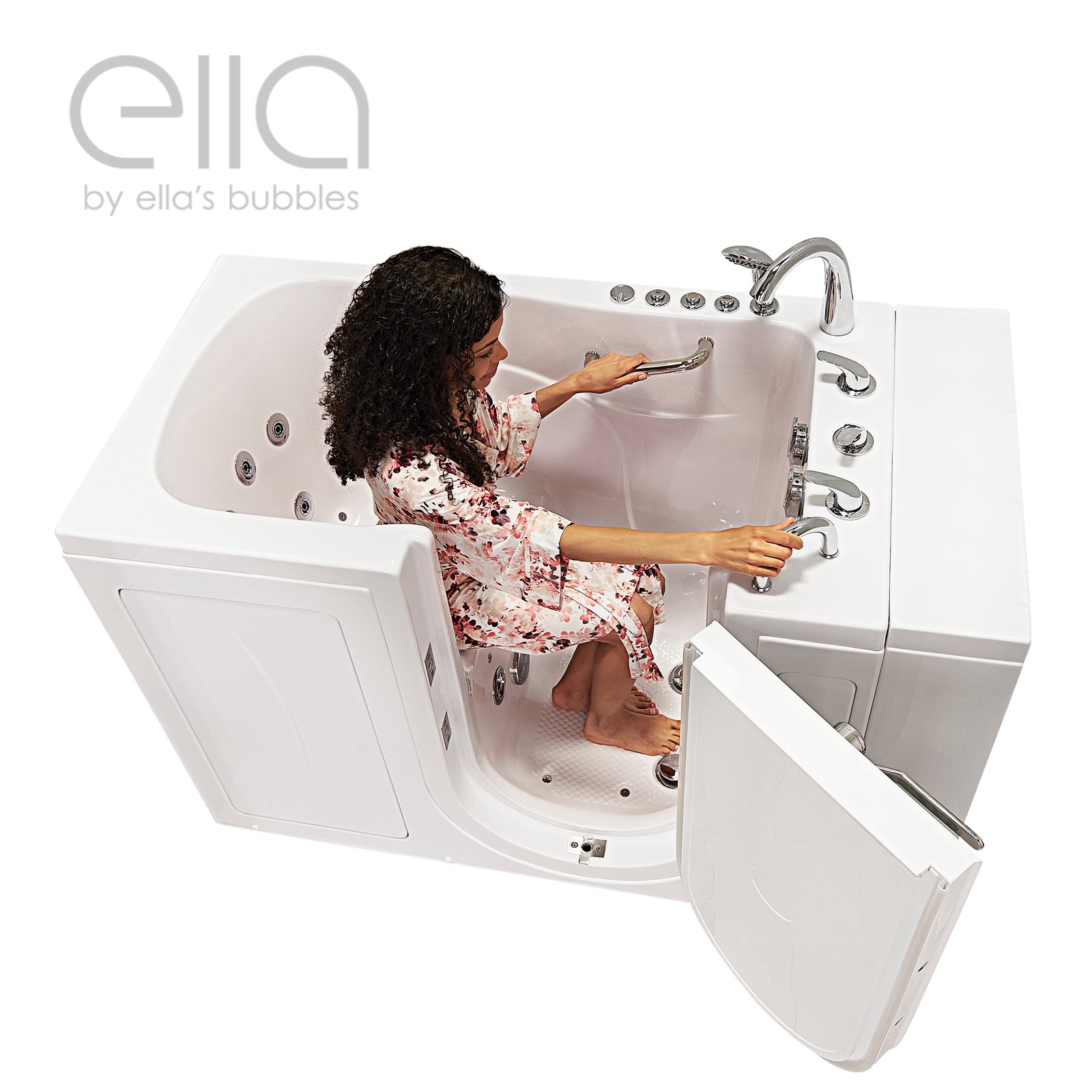 Woman in floral robe seated inside the Ella Monaco walk-in tub gripping grab bars with outward swing door open