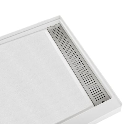 Primer plano de un plato de ducha con desagüe lineal de mármol cultivado blanco con rejilla lineal de acero inoxidable a lo largo del borde lateral