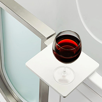 Close-up of a red wine glass resting on the white acrylic swivel tray attached to an Ella walk-in tub
