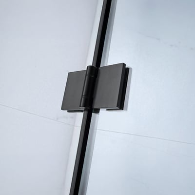 Primer plano de la bisagra pivotante en negro mate de la mampara de bañera plegable sin perfilería Ella Tidy con panel de cristal templado transparente