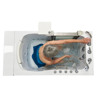 Overhead view of senior woman soaking in the Ella Elite walk-in tub with hydro jets and stainless steel controls visible