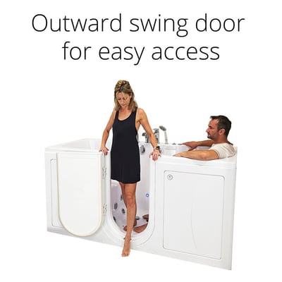 Woman stepping into Ella Big4Two two-seat walk-in tub through outward swing door while man relaxes inside soaking