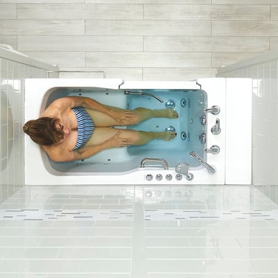 Overhead view of a woman relaxing in an Ella Ultra Acrylic walk-in tub with hydro jets and chrome dual drain controls