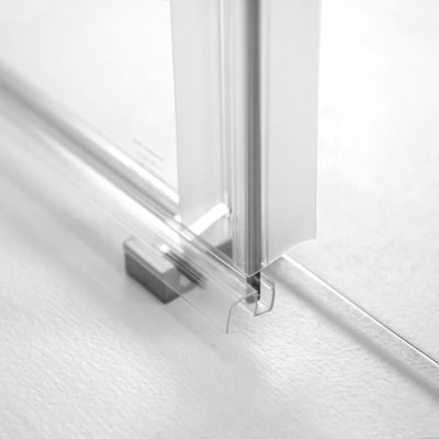 Primer plano de la junta inferior y el riel guía cromado en una puerta de ducha corredera de vidrio templado Primo de 6 mm