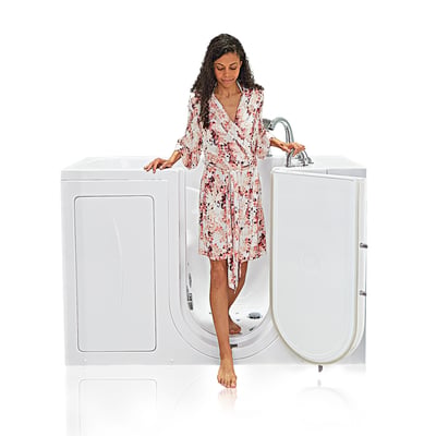 Woman in floral dress stepping into the Ella Capri walk-in tub with outward swing door open and grab bar support