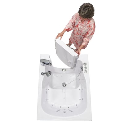 Femme âgée en haut fleuri ouvrant la porte battante vers l’extérieur d’une baignoire à porte Ella à entrée frontale, vue de dessus