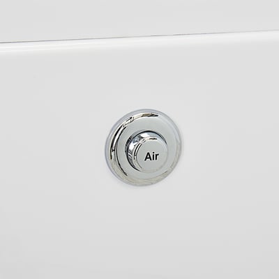 Gros plan d'un bouton de commande de jet d'air chromé sur la paroi en acrylique blanc d'une baignoire à porte Ella