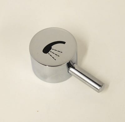 Gros plan d'une vanne d'inversion chromée pour baignoire à porte avec levier rallongé conforme ADA et symbole de douche