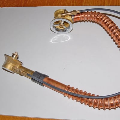 Ella walk-in tub drain assembly with copper coil tubing, brass fittings, and suction cup mounts laid flat on white surface