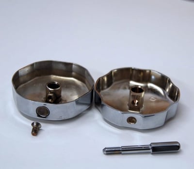 Two chrome walk-in tub drain opener kit components with center posts, screws, and a removal tool on white background