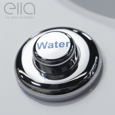 Gros plan d'un bouton de commande de jet d'eau chromé sur la surface en acrylique d'une baignoire à porte Ella