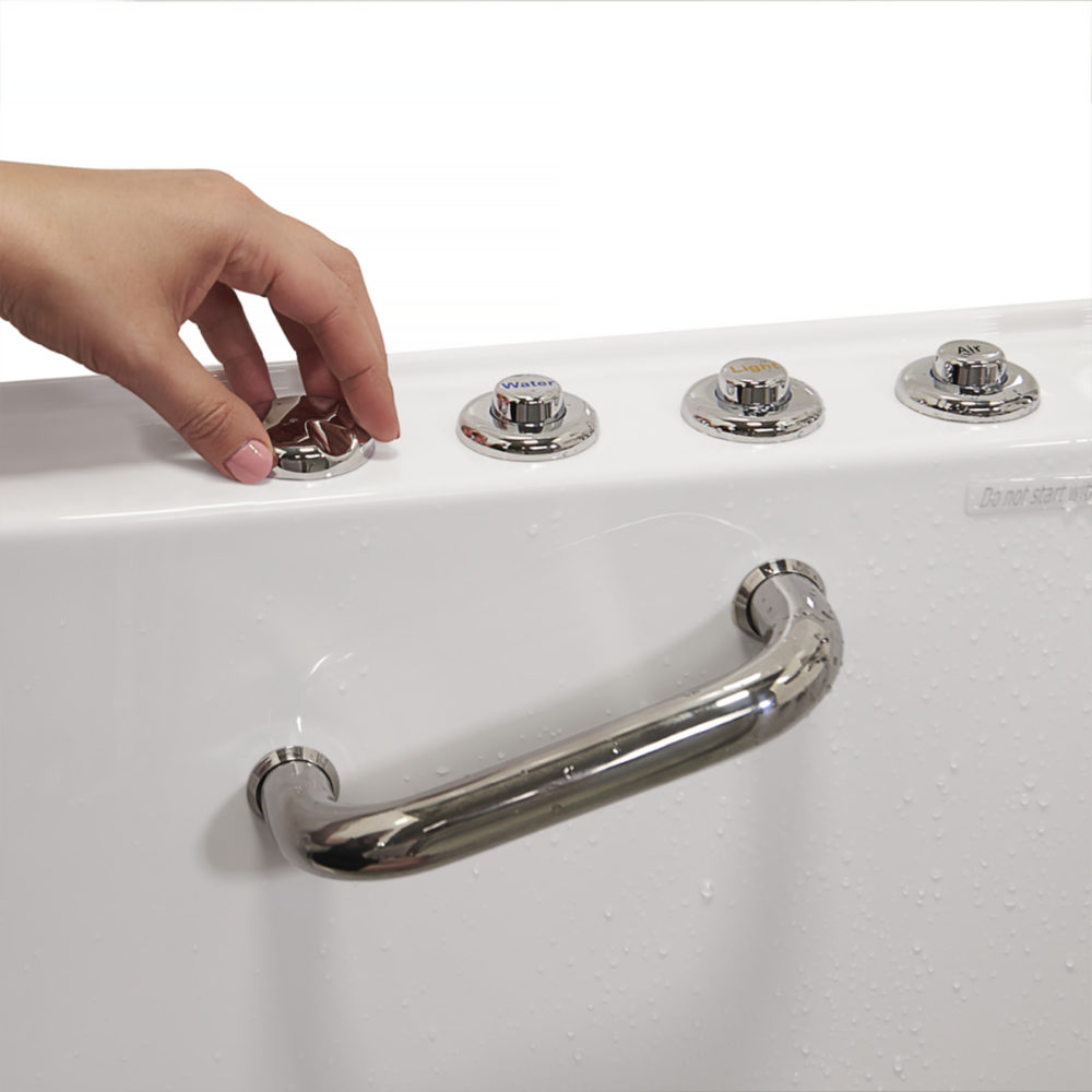 Hand pressing the chrome push-button controls on the deck of an Ella Ultimate walk-in tub