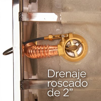 Primer plano de un desagüe roscado de latón de 2 pulgadas con bobina de tubo de cobre instalado debajo de una bañera con puerta de Ella