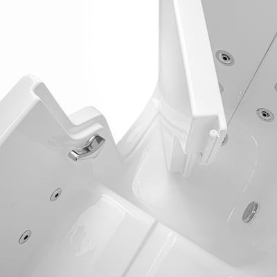 Open inward swing door of a walk in tub seen from above, with the chrome latch, jets and textured floor inside.