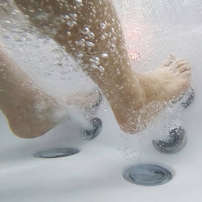 Underwater view of feet receiving a hydro jet foot massage inside an Ella's Bubbles walk-in tub with air jets active