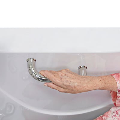 Senior's hand gripping a chrome safety grab bar mounted on the exterior of an Ella walk-in tub for support