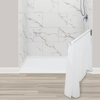 Cabine de douche accessible avec murs d'enceinte en marbre, base à seuil bas et rideau blanc pour aidant sur barre chromée