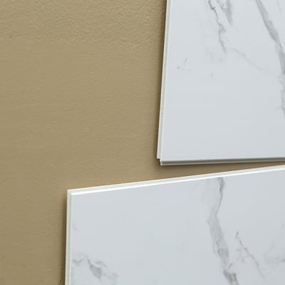 Primer plano de paneles de pared de ducha sin lechada con aspecto de mármol Carrara blanco que muestra bordes laminados y un acabado de superficie lisa