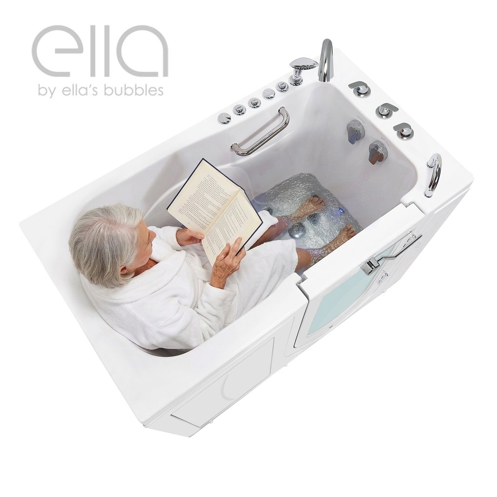 Senior woman in white robe reading a book while soaking feet in the Ella Monaco outswing door walk-in tub with hydro jets
