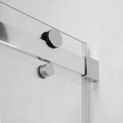 Close-up of chrome sliding track hardware and tempered glass panel on an Ella accessible shower stall door
