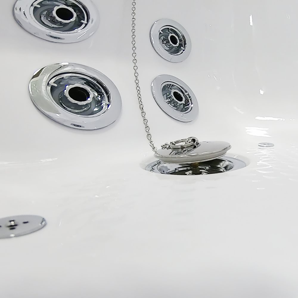 Close-up of the chrome drain plug with pull chain beside hydro jets inside an Ella Mobile walk-in tub