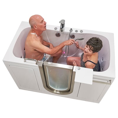 Senior couple bathing together in the Ella Companion two-seat walk-in tub while man uses handheld showerhead to rinse smiling woman