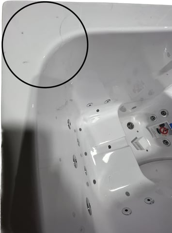 Gros plan de l’intérieur de la baignoire à porte Ella Tub4Two montrant une fissure de surface entourée sur l’acrylique blanc près du coin supérieur