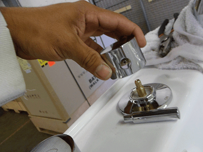 Technicien installant une vanne d’inverseur chromée sur une baignoire à porte lors de l’assemblage dans un site Ella’s Bubbles