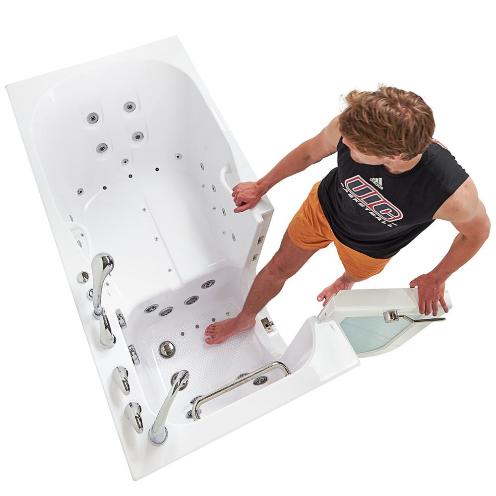 Man stepping into an Ella walk-in tub with outward swing door open, showing air jets, grab bars, and anti-slip floor