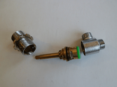 Two disassembled chrome diverter valve components with brass stem and green seal for walk-in tub plumbing repair