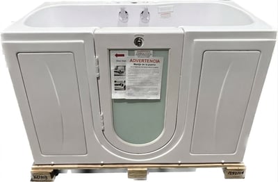 Bañera de acceso de acrílico blanco Ella Tub4Two con puerta de apertura exterior y grifos dobles mostrada sobre un palé de envío