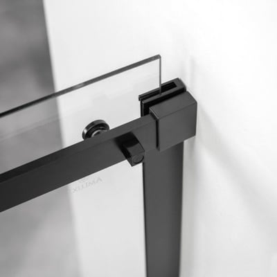 Gros plan de la quincaillerie à roulettes noir mat et du support de pince à verre sur la porte de douche coulissante en verre trempé Ella Primo
