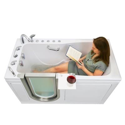 Woman relaxing and reading a book in the Ella Ultimate walk-in tub with a glass of red wine on the swivel tray