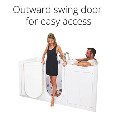 Woman stepping into Ella Big4Two two-seat walk-in tub through the outward swing door while a man relaxes inside