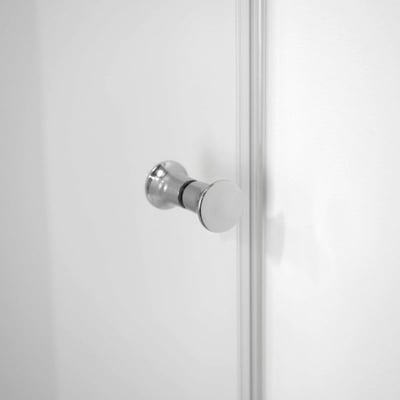 Gros plan d’une poignée bouton en chrome poli sur un panneau de porte de douche coulissante en verre trempé blanc