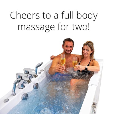 Couple toasting with champagne glasses while enjoying a hydro massage in the Ella Big4Two two-seat walk-in tub