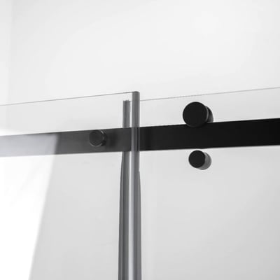Primer plano de los herrajes de la puerta corredera en negro mate y el panel de vidrio templado transparente en la puerta de ducha accesible Ella Primo