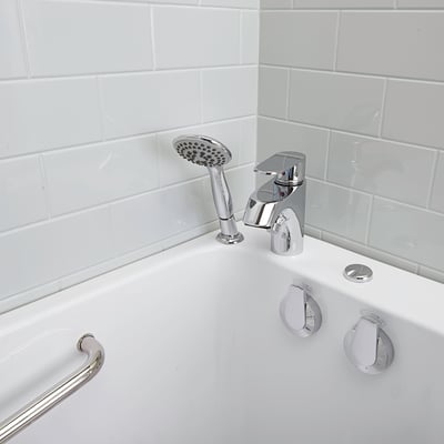 Gros plan d’un ensemble de robinetterie chromé 2 pièces avec douchette et manettes de commande sur le rebord d’une baignoire à porte Ella Lounger