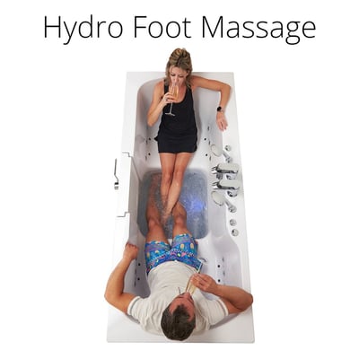Couple relaxing in the Ella Big4Two two-seat walk-in tub enjoying hydro foot massage jets with drinks from overhead view