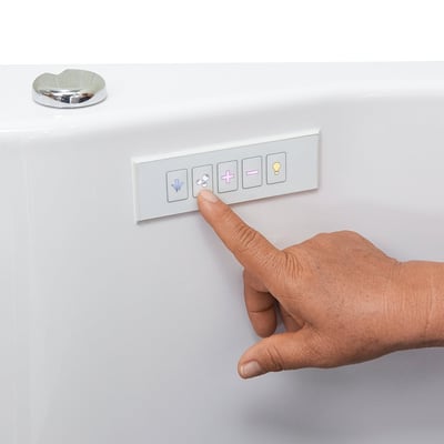 Close-up of a hand pressing the touch control panel on an Ella walk-in tub with jet and lighting buttons