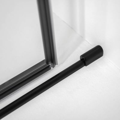 Gros plan du rail inférieur noir mat et de la fixation murale sur la porte de douche coulissante en verre trempé Ella Primo