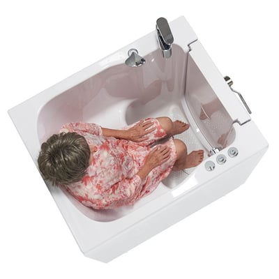 Vue de dessus d’une femme âgée assise dans une baignoire à porte Ella à entrée frontale montrant l’intérieur spacieux 32 × 40 avec sol antidérapant et robinet chromé