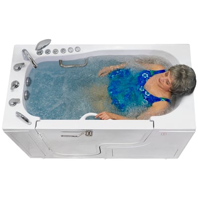 Senior woman relaxing in an Ella Transfer 30 walk-in tub with dual massage jets creating bubbling water around her