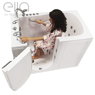 Woman seated inside the Ella Capri walk-in tub gripping grab bar with outward swing door open showing interior jets and seat