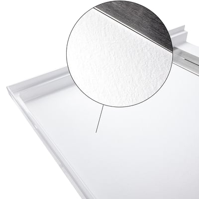 Close-up of textured anti-slip SMC shower pan surface with stainless steel linear drain for ADA accessible bathrooms