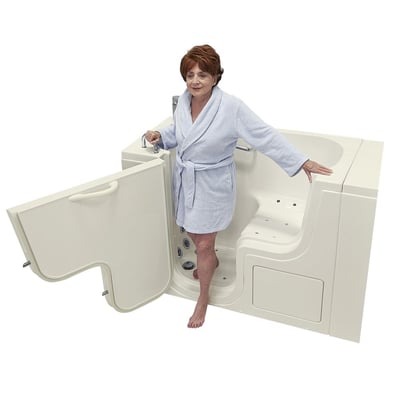 Senior woman in a robe stepping into the Ella Transfer30 ADA accessible walk-in tub with open outswing door and grab bars