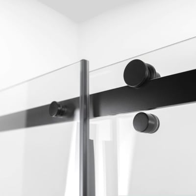 Gros plan de la quincaillerie de porte coulissante noir mat et du panneau en verre trempé sur la cabine de douche accessible Ella Primo